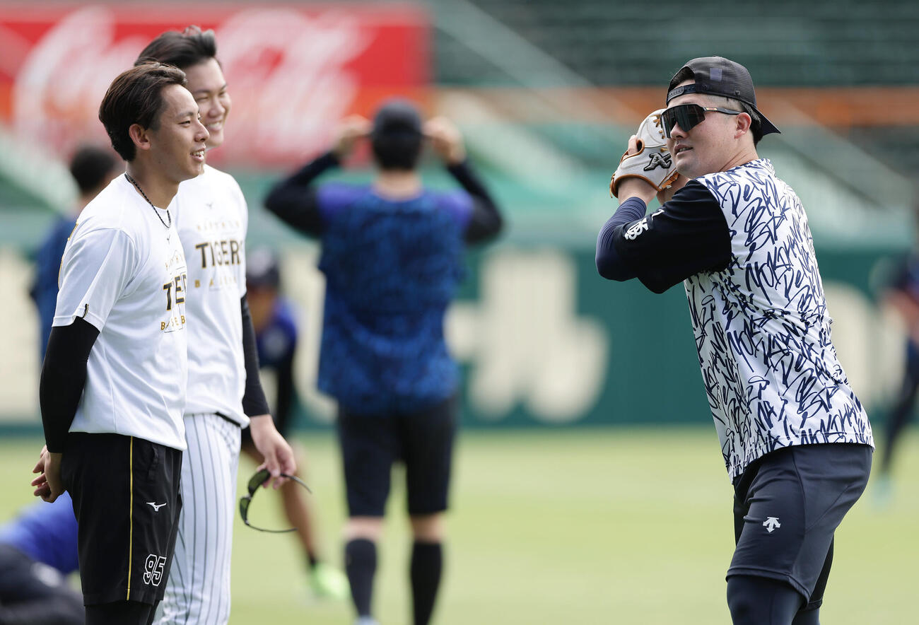 阪神対DeNA　試合前練習でDeNA牧秀悟（右）と言葉を交わす阪神神宮僚介（左）、及川雅貴（撮影・前田充）