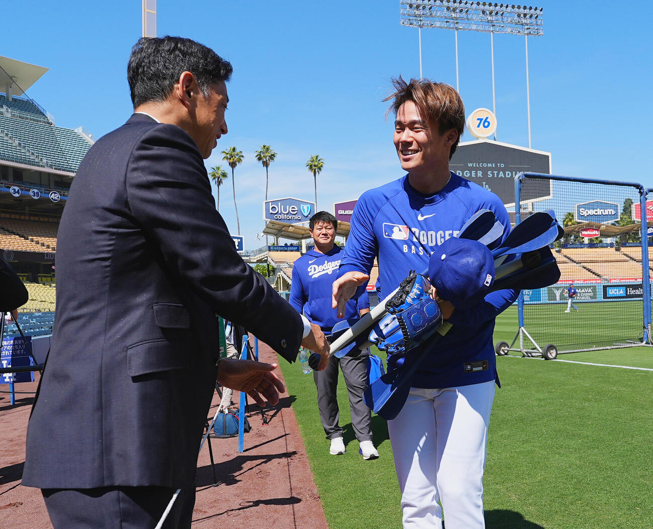 オープン戦・ドジャース対エンゼルス　試合前、田口氏（左）に握手であいさつするドジャース山本（2025年3月23日撮影）