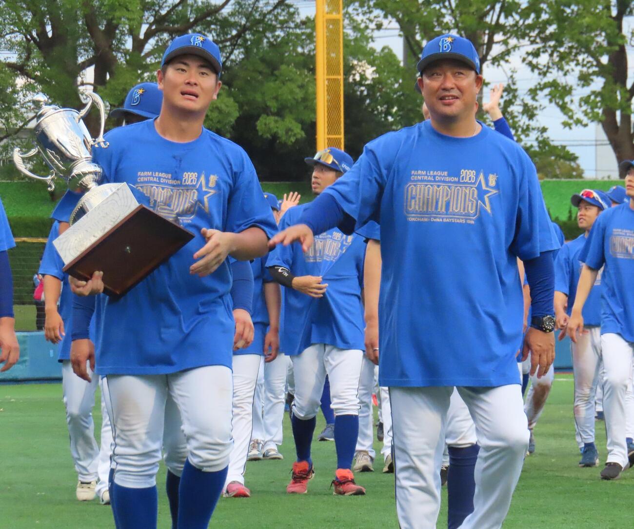優勝トロフィーを持って場内一周するDeNA高見沢（左）と村田2軍監督