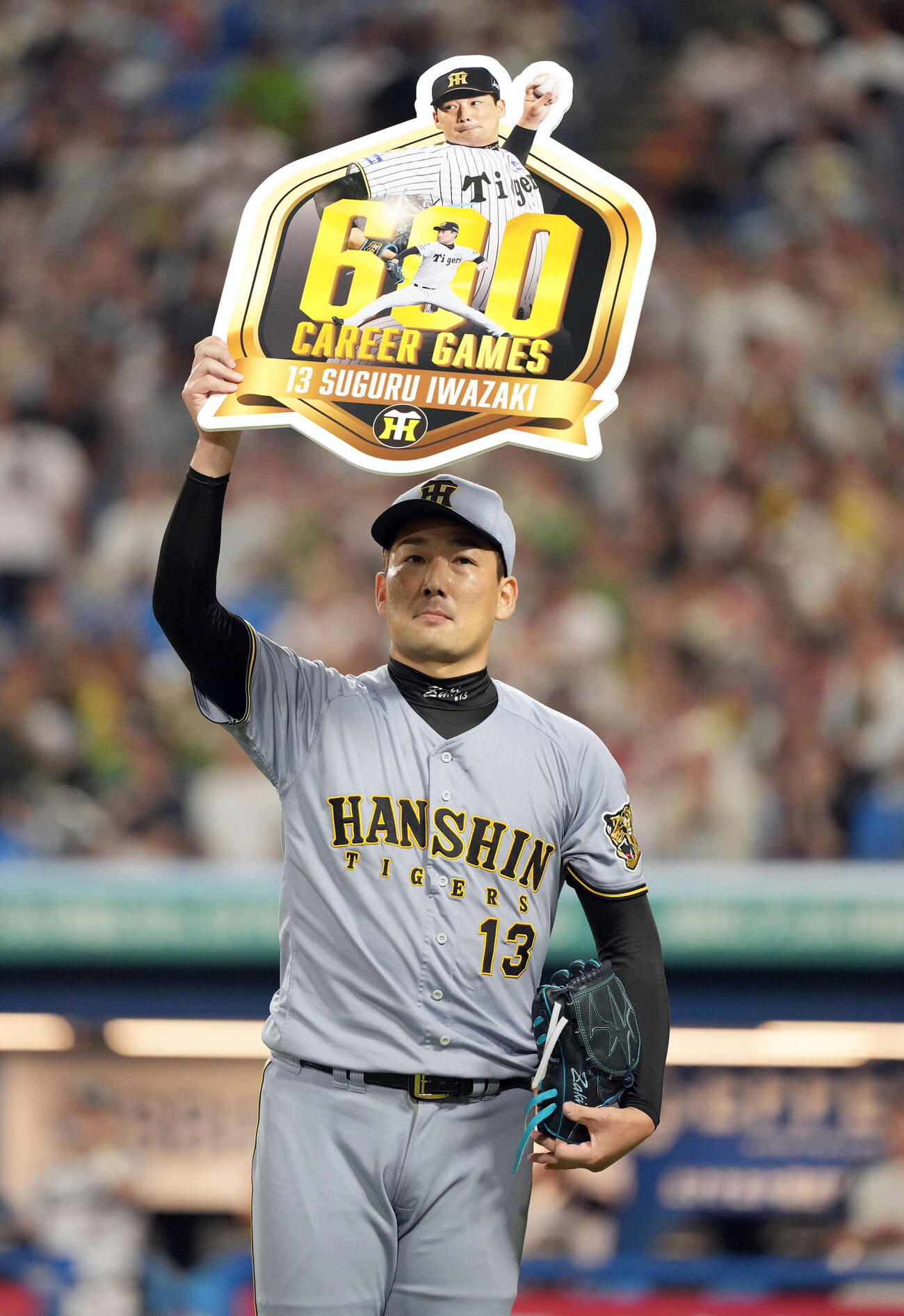 ヤクルト対阪神　8回、通算600試合登板を達成し記念ボードを掲げる阪神岩崎優（撮影・たえ見朱実）
