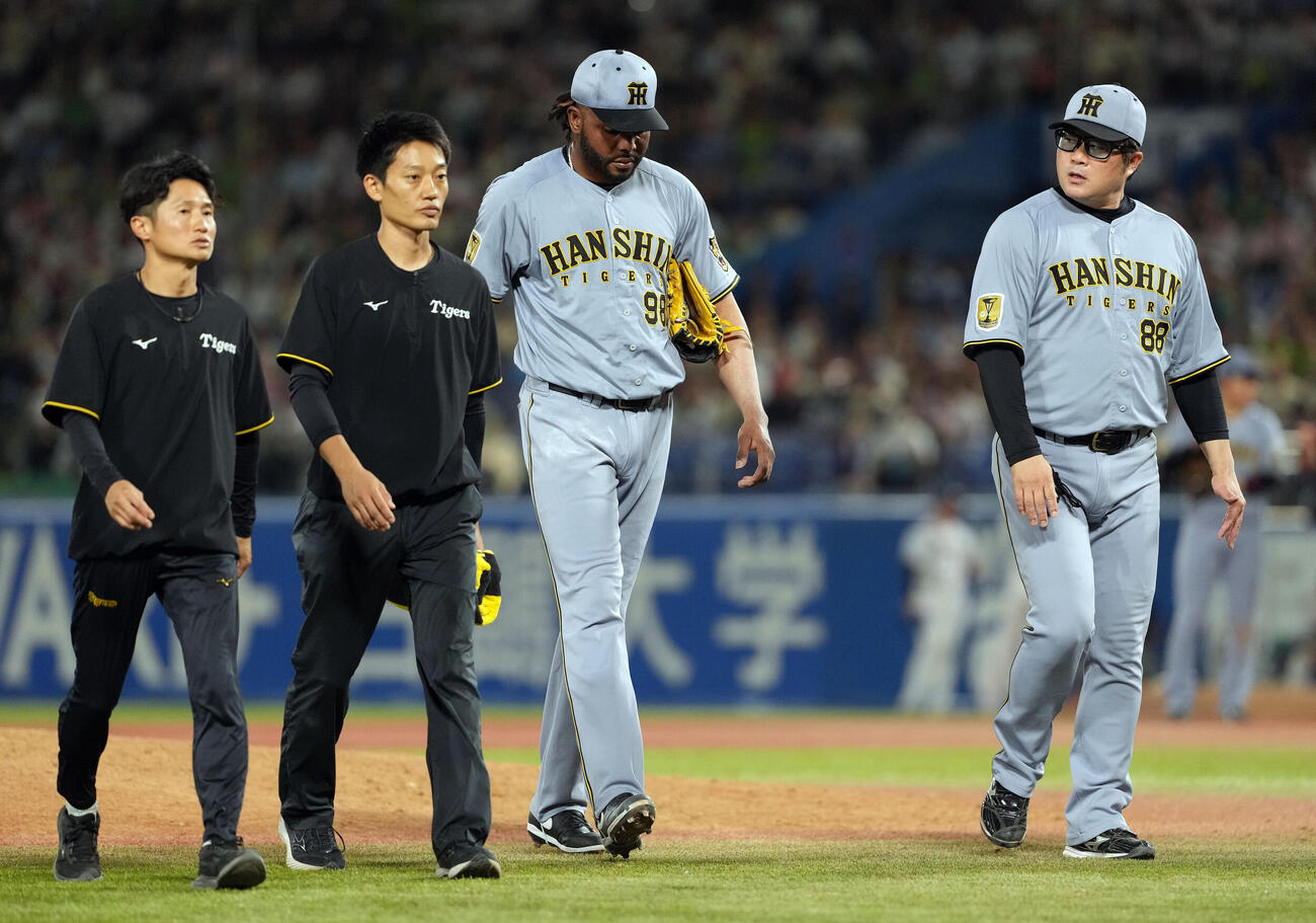 ヤクルト対阪神　10回、投手コーチ、トレーナーに付き添われ降板する阪神ラファエル・ドリス（撮影・たえ見朱実）