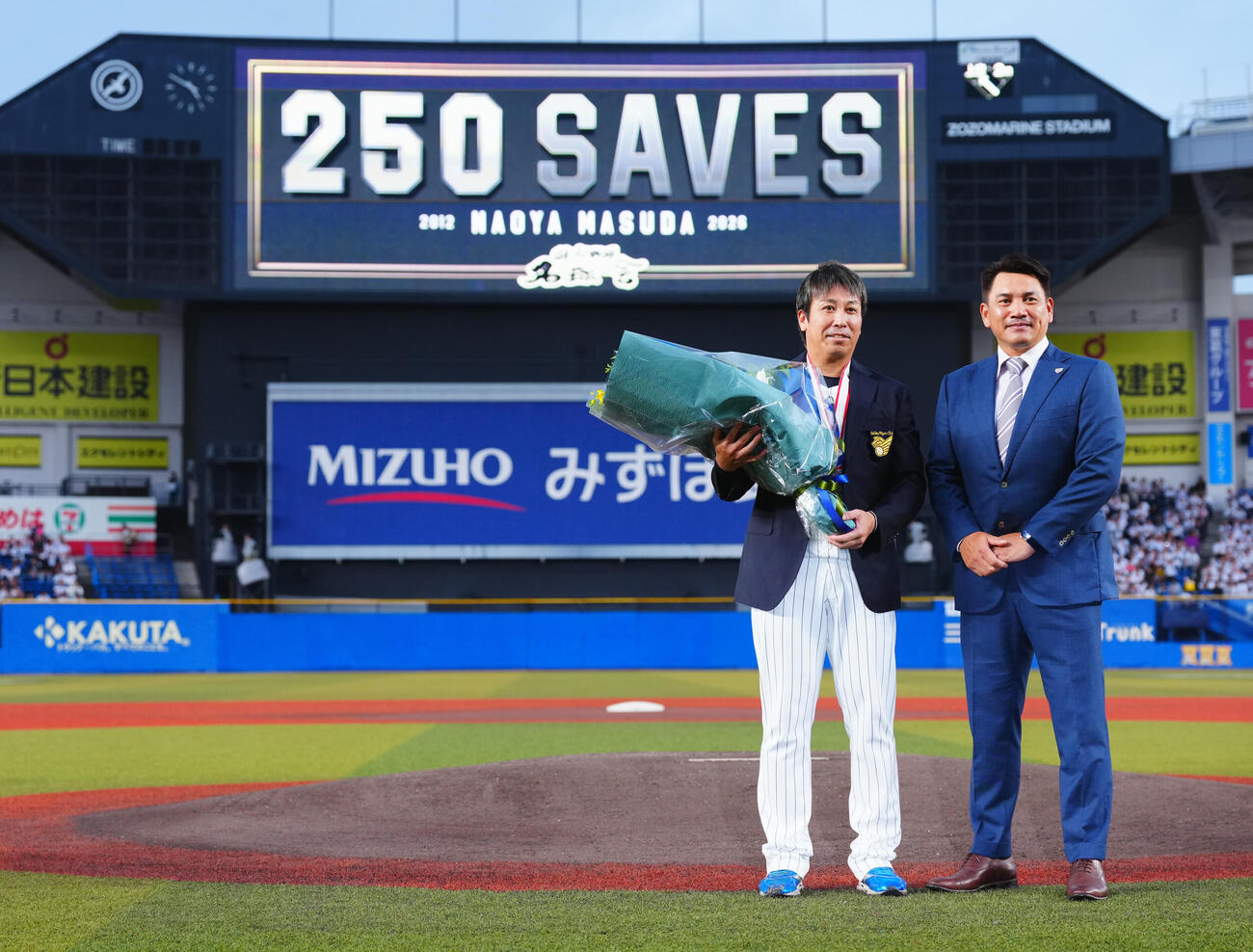 ロッテ対オリックス　通算250セーブを達成したロッテ益田直也（左）は侍ジャパン井口資仁監督から花束を贈られ写真に納まる（撮影・垰建太）