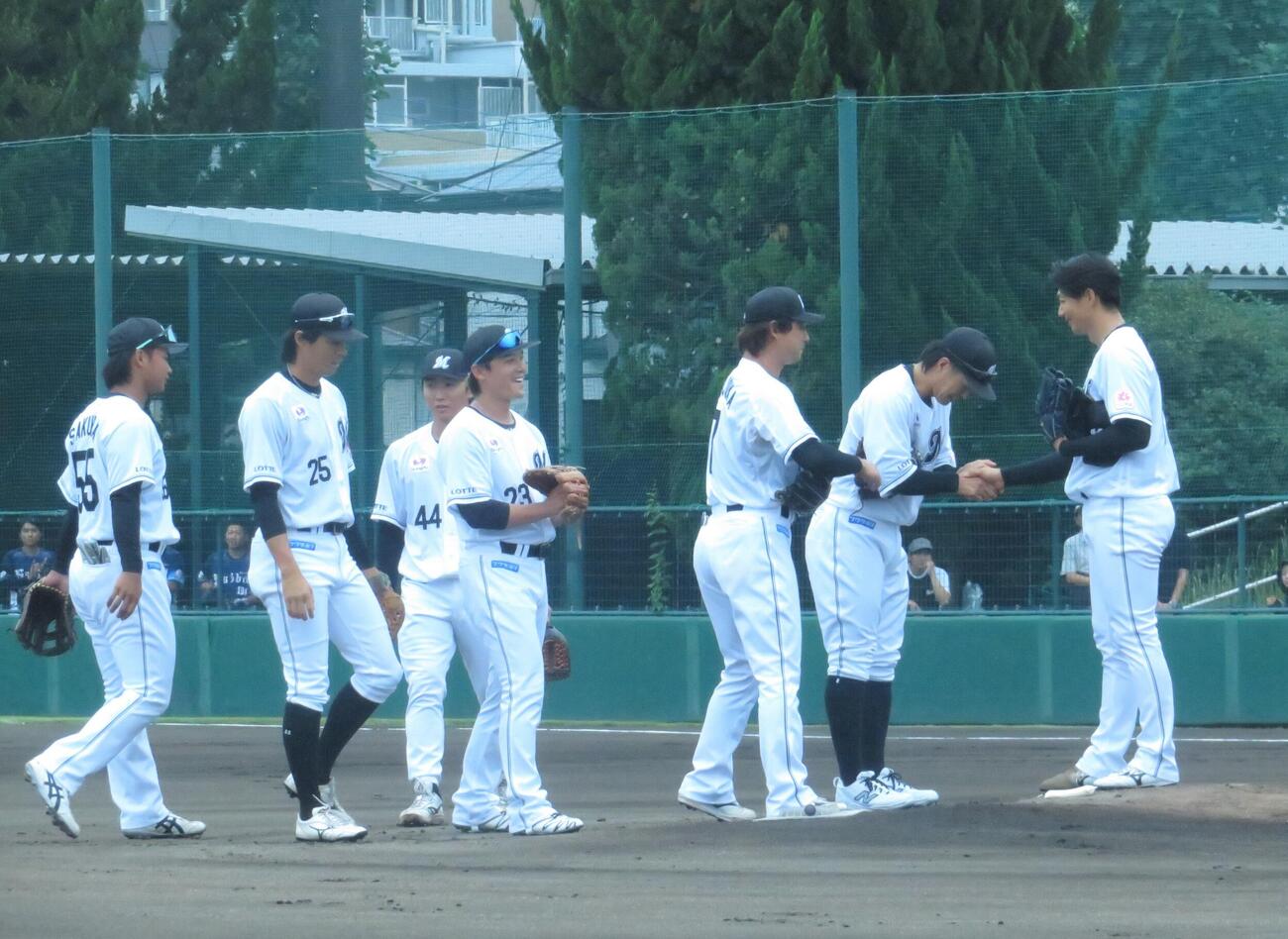 打者1人の登板を終え野手一人一人と握手をする唐川侑己（右)
