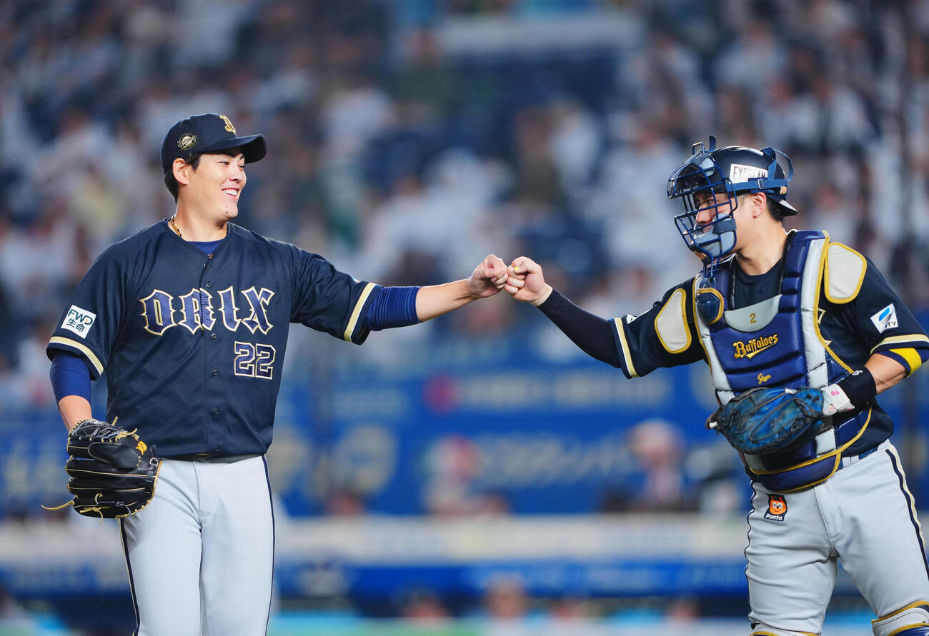 ロッテ対オリックス　5回裏ロッテ1死一、二塁、山崎剛を一直併殺に仕留め無失点の九里亜蓮（左）は若月健矢と笑顔でタッチを交わす（撮影・垰建太）