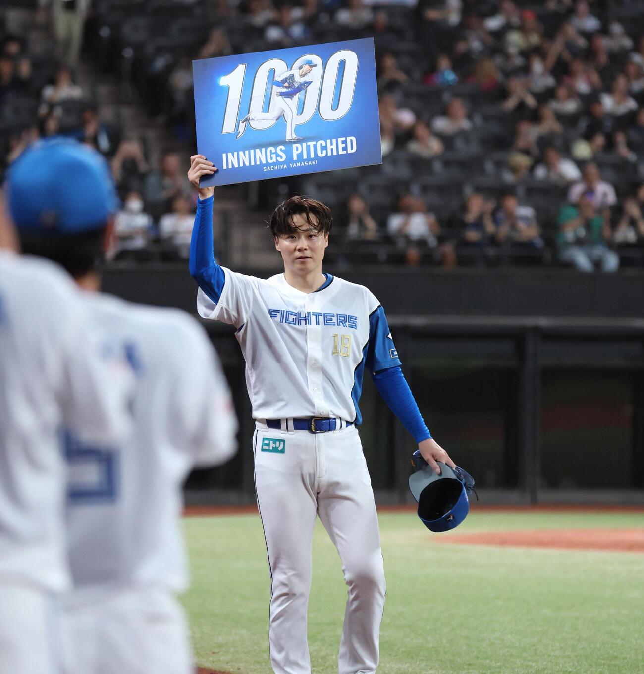 日本ハム対楽天　通算1000投球回を達成し記念ボードを掲げる山崎福也（撮影・黒川智章）