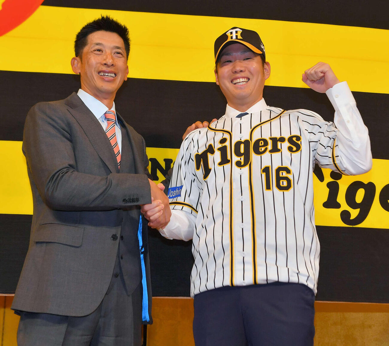 18年12月、入団会見で矢野燿大監督（左）と握手を交わし笑顔を見せる西勇輝