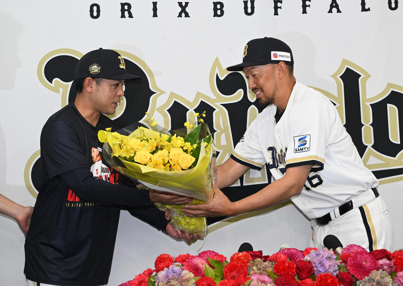 引退会見後、比嘉幹貴コーチ（左）から花束を贈られるオリックス平野佳寿（撮影・和賀正仁）