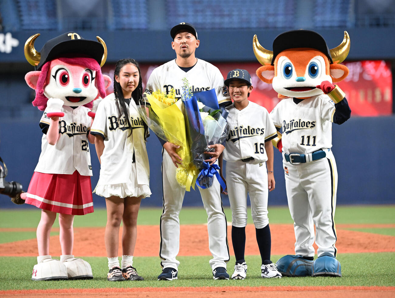 子ども達から花束を贈られ記念撮影するオリックス平野佳寿（撮影・和賀正仁）