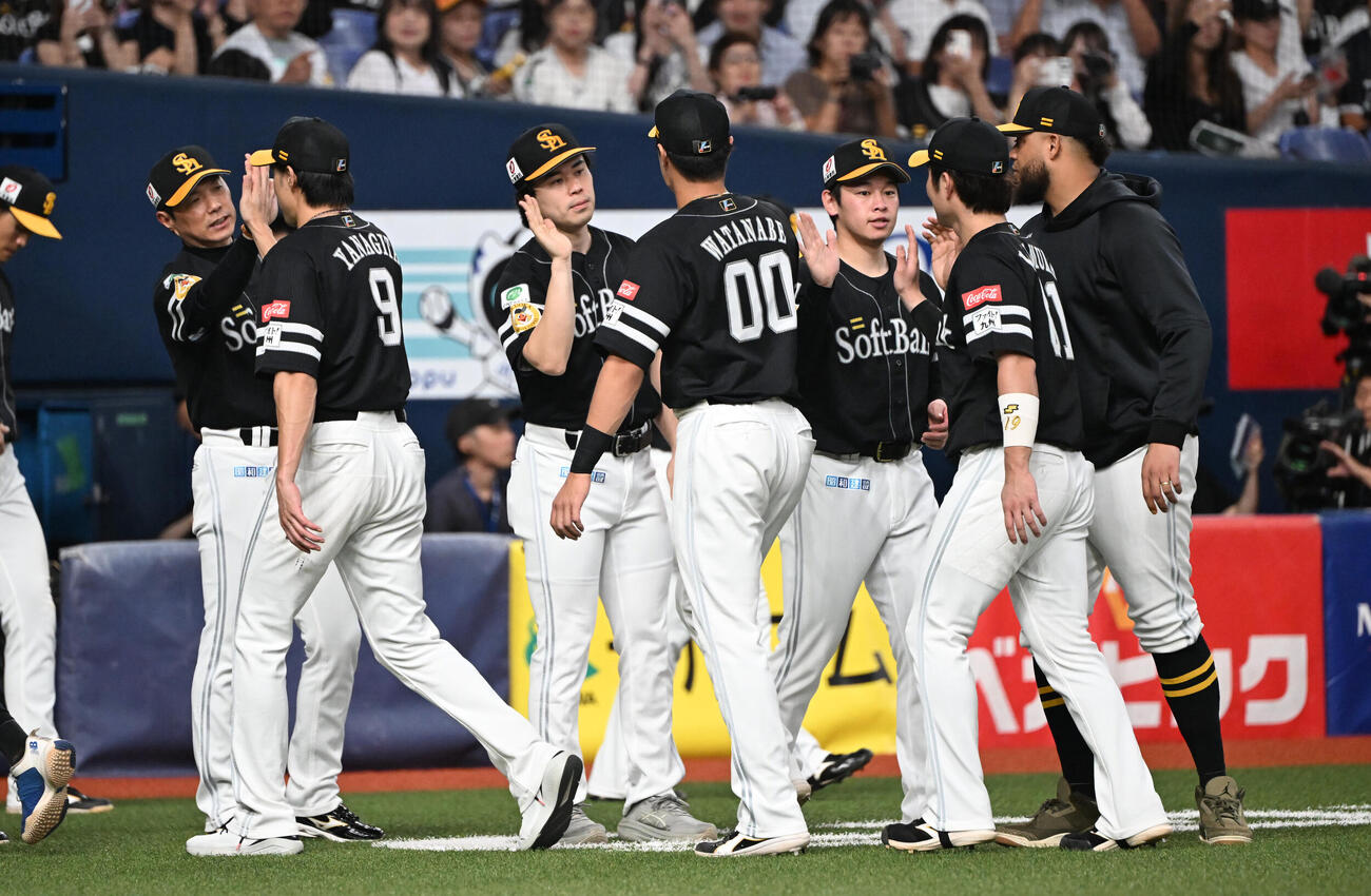 オリックスに勝利しハイタッチで迎えるソフトバンク小久保裕紀監督（左）と松本晴（撮影・和賀正仁）