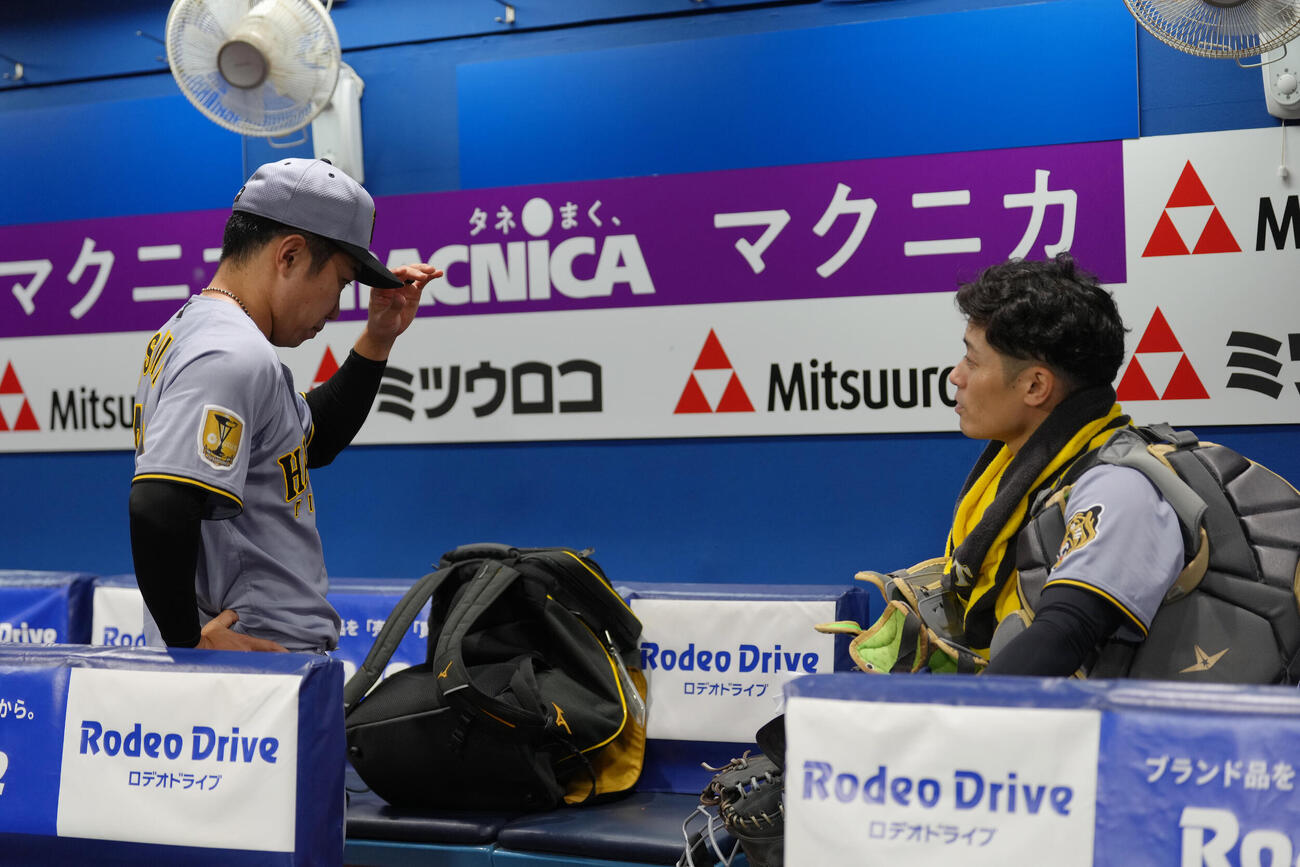 DeNA対阪神　試合後、ベンチに残り石井大智（左）に言葉を掛ける阪神坂本誠志郎（撮影・足立雅史）