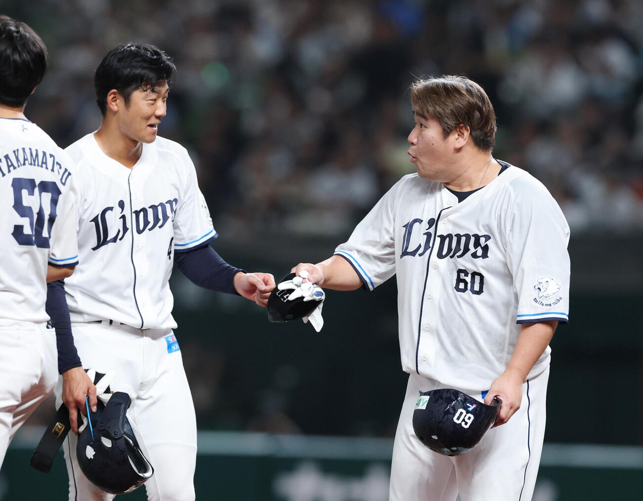 西武対ロッテ　サヨナラ勝ちしタッチを交わす石井一成（左）と中村剛也（撮影・増田悦実）