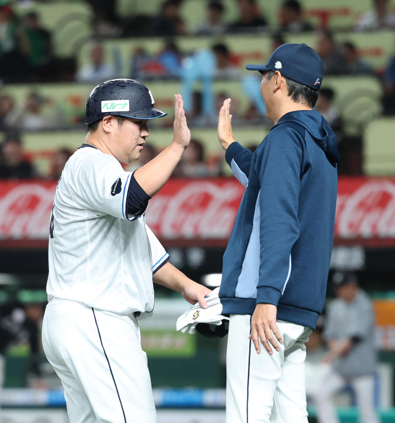 西武対ロッテ　サヨナラ勝ちしタッチを交わす中村剛也（左）と西口文也監督（撮影・増田悦実）