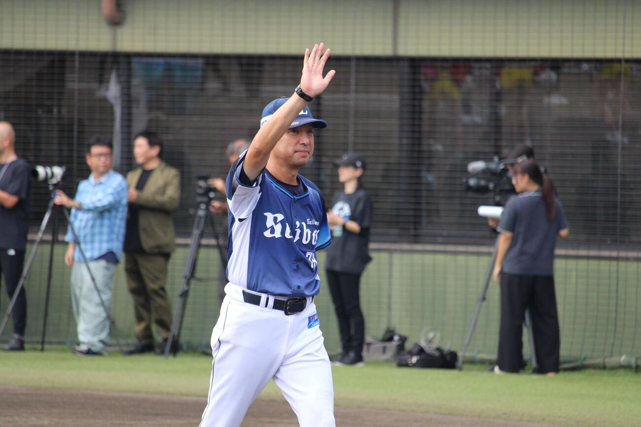 試合前あいさつを終えファンの声援に手を振る西武小関ファーム監督（撮影・金子真仁）