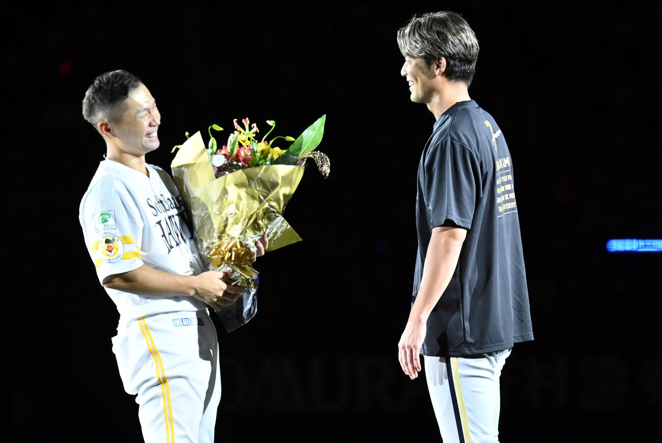 ソフトバンク対オリックス　中村晃（左）に花束を贈るオリックス岩川翔（撮影・林敢治）