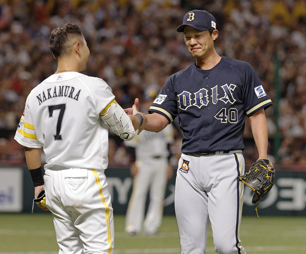 7回、現役最後の打席を終え、対戦したオリックス・岩崎（右）と握手を交わすソフトバンク・中村晃（共同）
