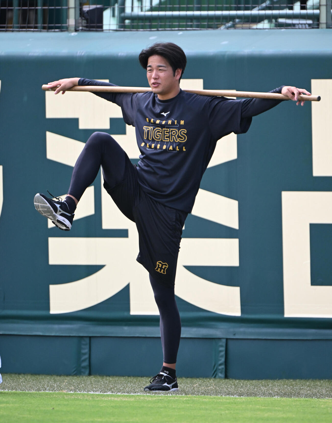 棒を使ってストレッチする阪神高橋遥人（撮影・和賀正仁）