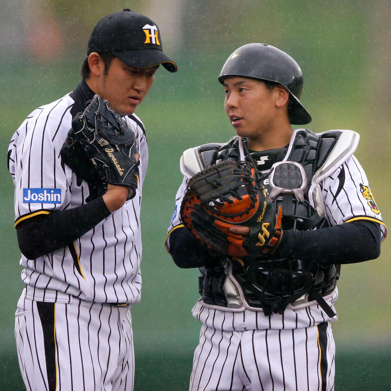 2014年2月、練習試合の楽天戦で、ブルペンで話す阪神岩貞祐太（左）と梅野隆太郎