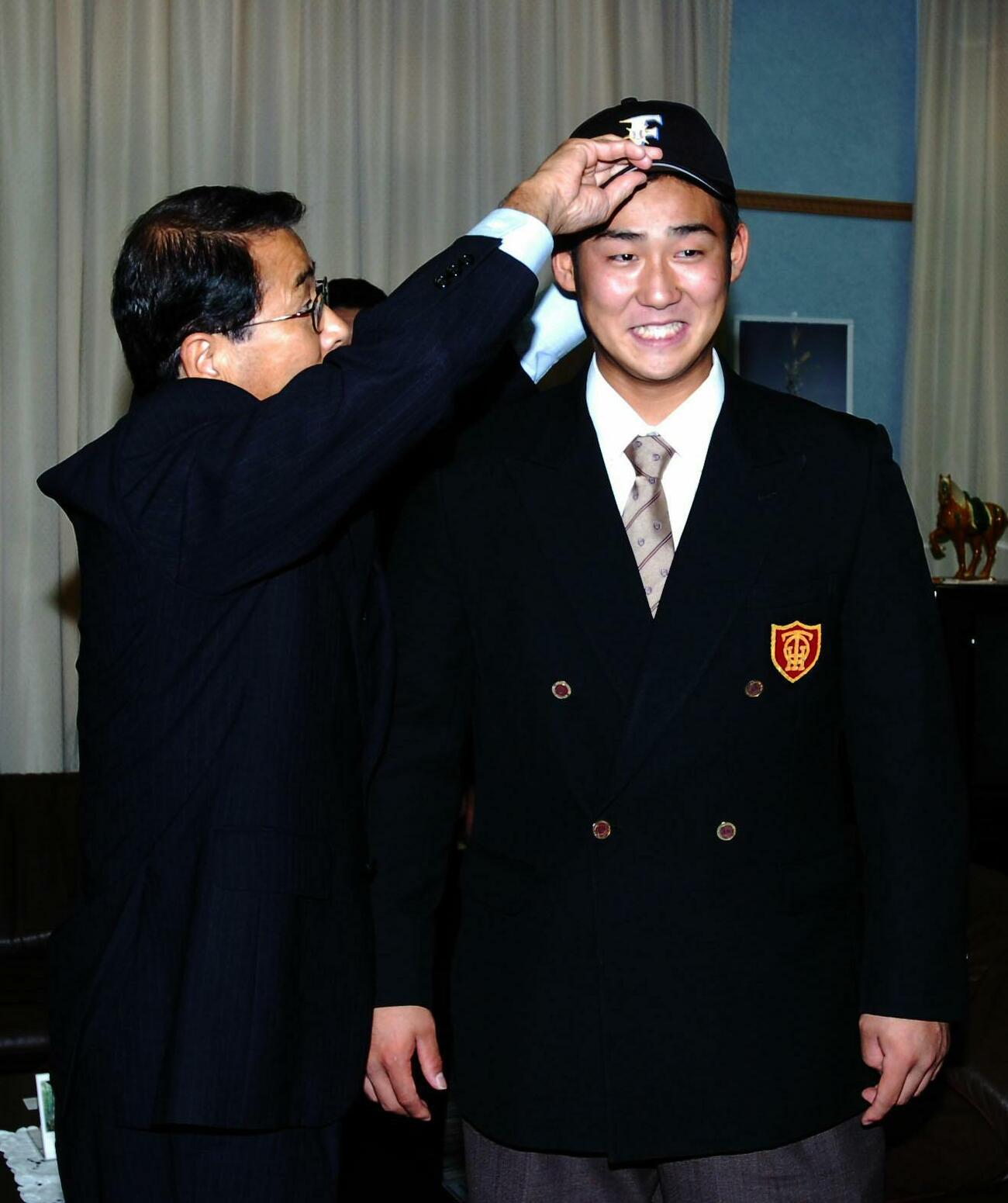 2007年高校生ドラフト・日本ハム指名あいさつ　中田翔（右）に帽子をかぶせる高田繁GM（2007年10月撮影）