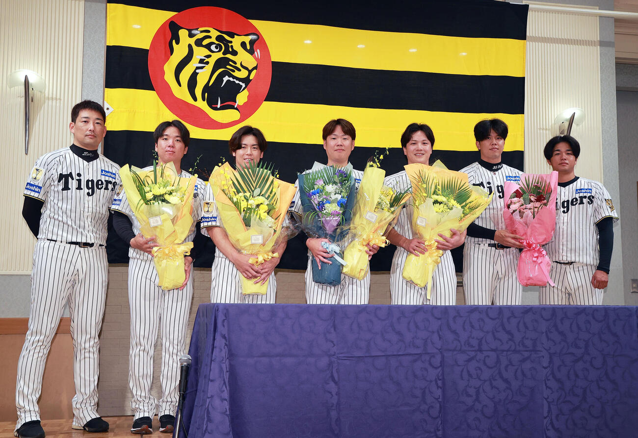 仲間たちがサプライズで登場し記念撮影する阪神西勇輝（中央）。左から岩崎優、村上頌樹、梅野隆太郎、1人おいて伏見寅威、才木浩人、高橋遥人（撮影・上山淳一）