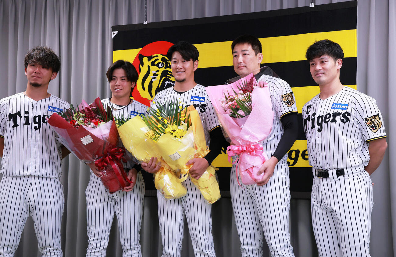 サプライズで登場した仲間と記念撮影する阪神岩貞祐太（中央）、左から伊藤将司、梅野隆太郎、一人おいて岩崎優、坂本誠志郎（撮影・上山淳一）