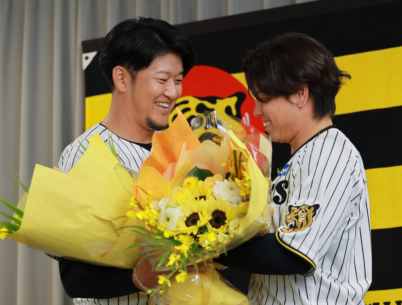 サプライズで登場した梅野隆太郎（右）から花束を受け取る岩貞祐太（撮影・上山淳一）
