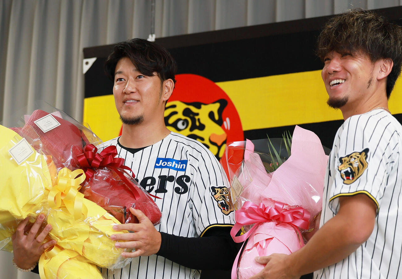 サプライズで登場した伊藤将司（右）らから花束を受け取る岩貞祐太（撮影・上山淳一）