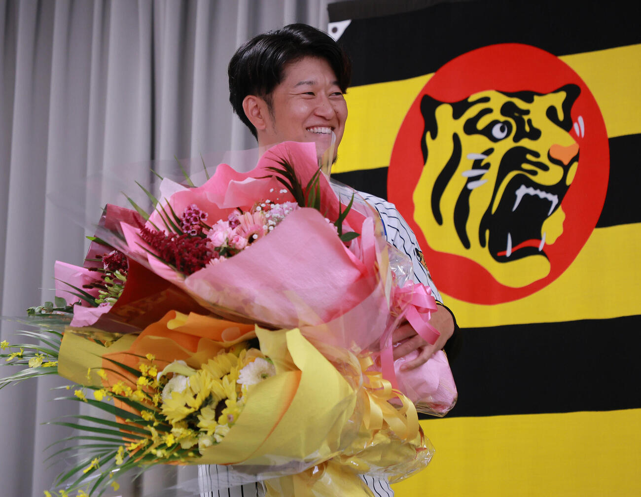阪神岩貞祐太はサプライズで登場した仲間から花束を受け笑顔を見せる（撮影・上山淳一）