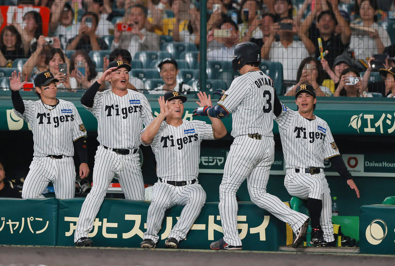 阪神対ヤクルト　2回裏阪神1死、大山悠輔（手前）はソロ本塁打を放ち祝福を受ける（撮影・上山淳一）