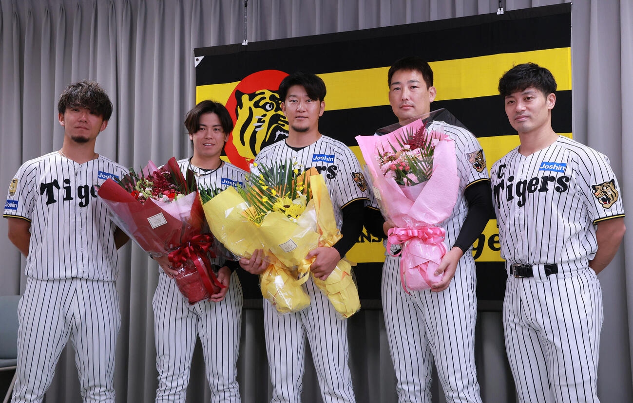 サプライズで登場した仲間と記念撮影する阪神岩貞祐太（中央）。左から伊藤将司、梅野隆太郎、一人おいて岩崎優、坂本誠志郎（撮影・上山淳一）