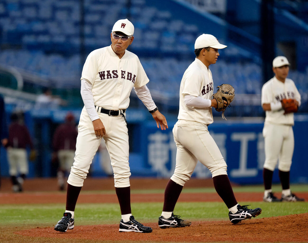早大対明大　8回明大2死満塁、浮かない顔で投手交代を告げた早大・小宮山悟監督（左）（撮影・山本朝陽）