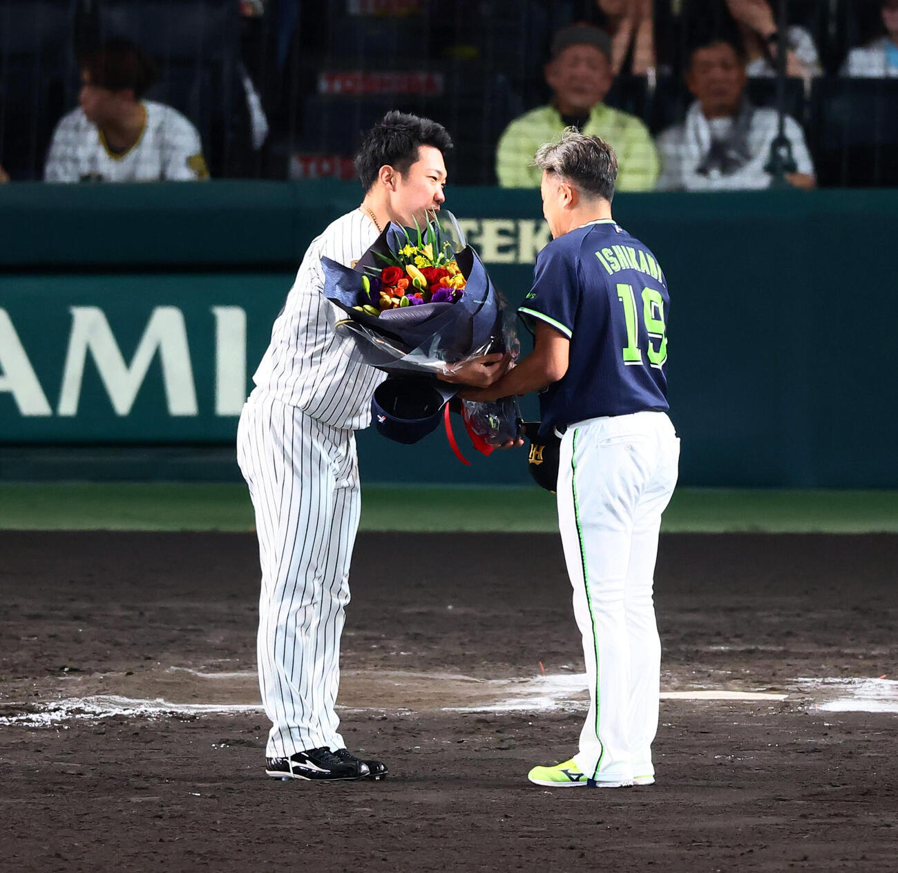 阪神対ヤクルト　試合後、阪神石井大智（左）からヤクルト石川雅規に花束が贈られた（撮影・加藤哉）