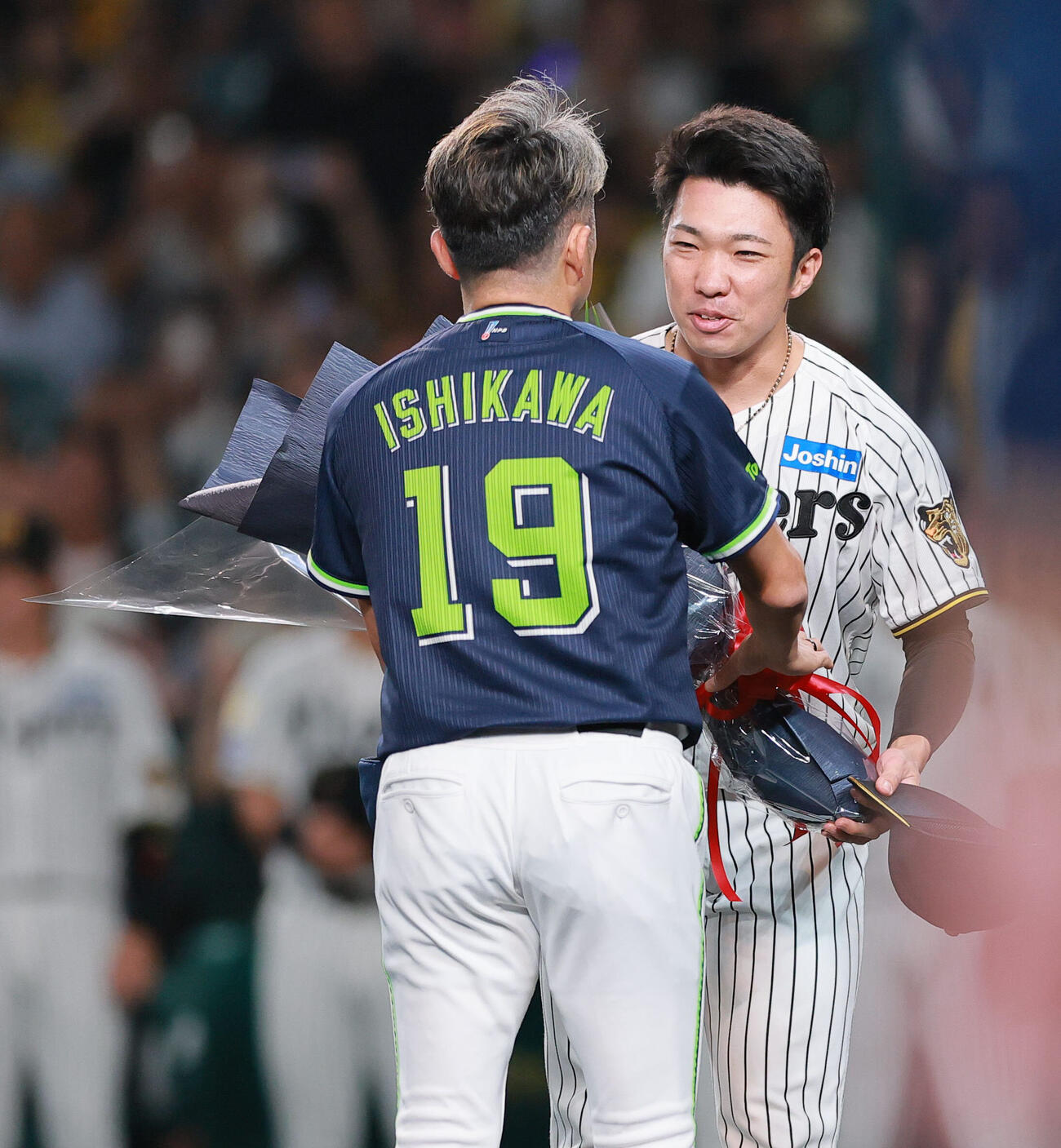 阪神対ヤクルト　現役引退を表明したヤクルト石川雅規（手前）に花束を渡す阪神石井大智（撮影・上山淳一）