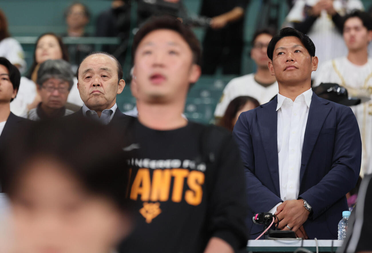 阪神対巨人　中継席で君が代を聴く岡田彰布氏（左）と原口文仁氏（撮影・宮崎幸一）