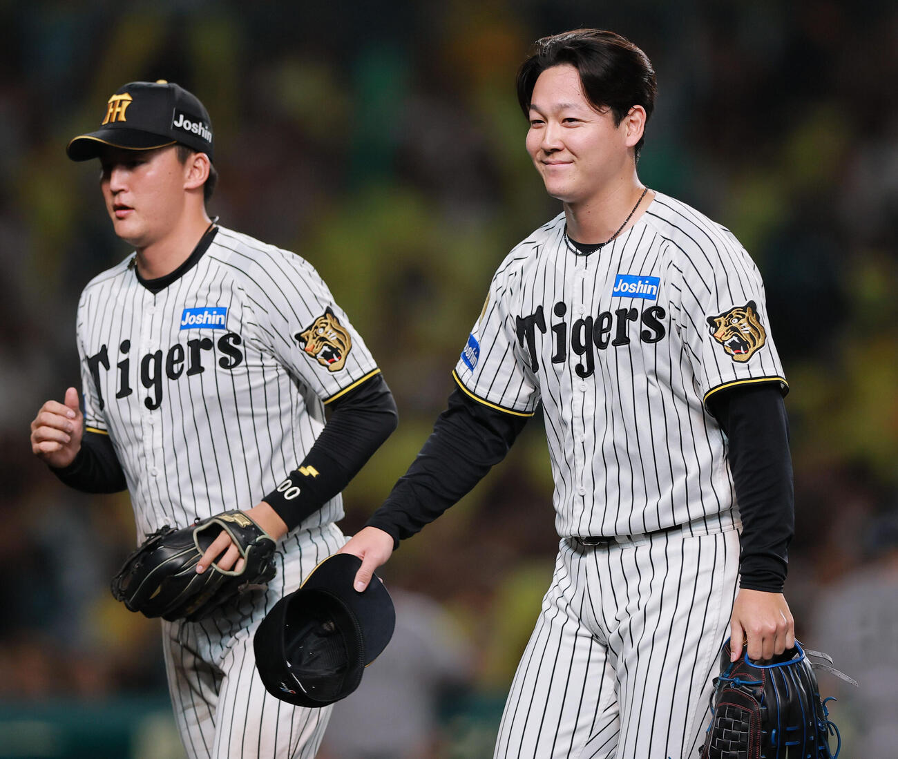 阪神対巨人　7回表を投げ終えた阪神木下里都（右）は笑顔でベンチに引きあげる（撮影・上山淳一）