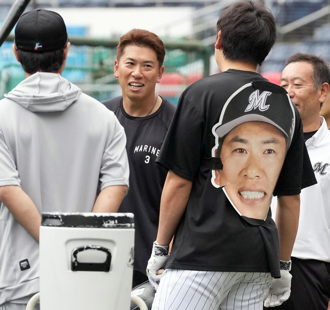ロッテ対ソフトバンク　自身の大型のお面を背負った安田尚憲と話をするロッテ角中勝也（撮影・たえ見朱実）