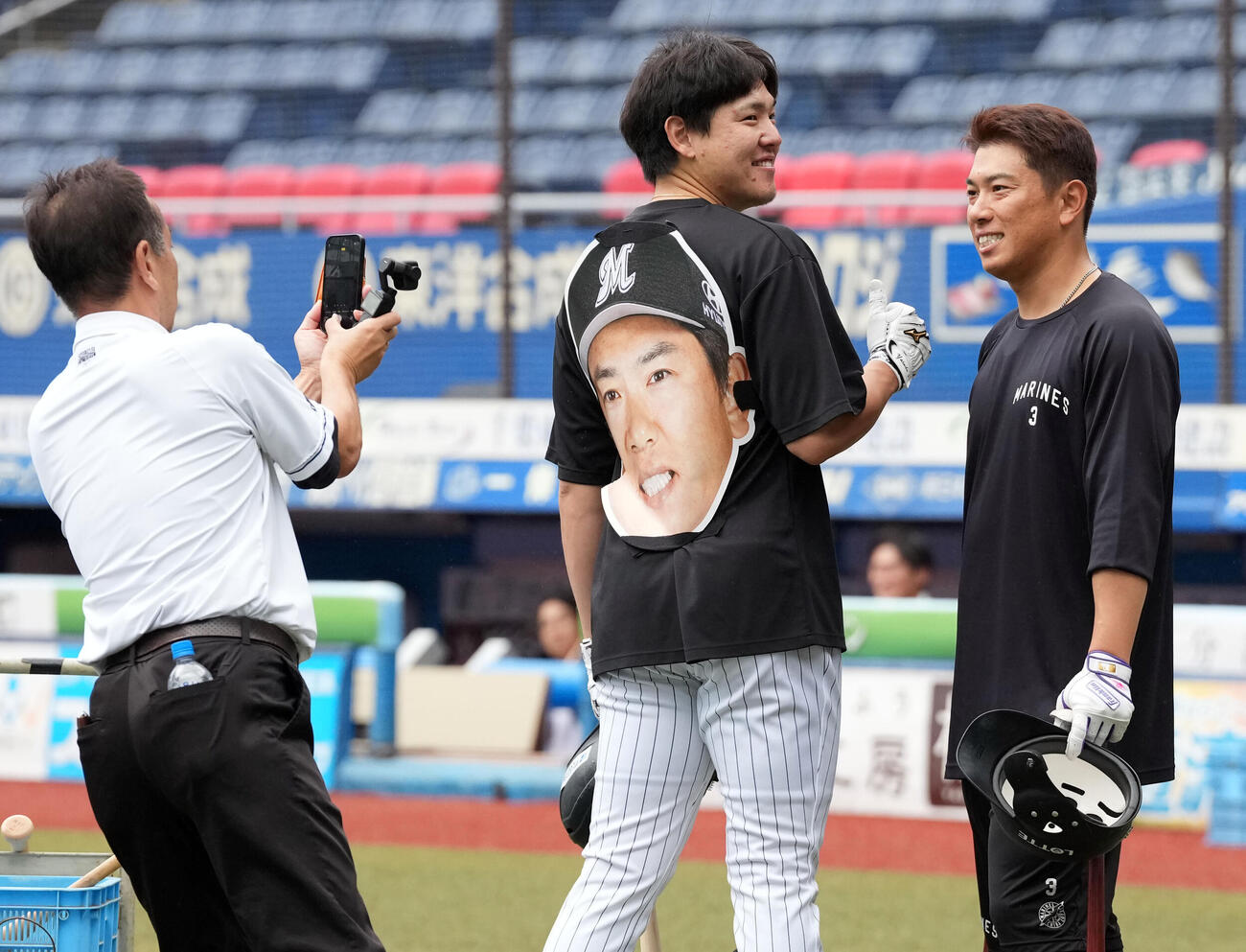 ロッテ対ソフトバンク　自身の大型のお面を背負ったロッテ安田尚憲と記念撮影する角中勝也（撮影・たえ見朱実）