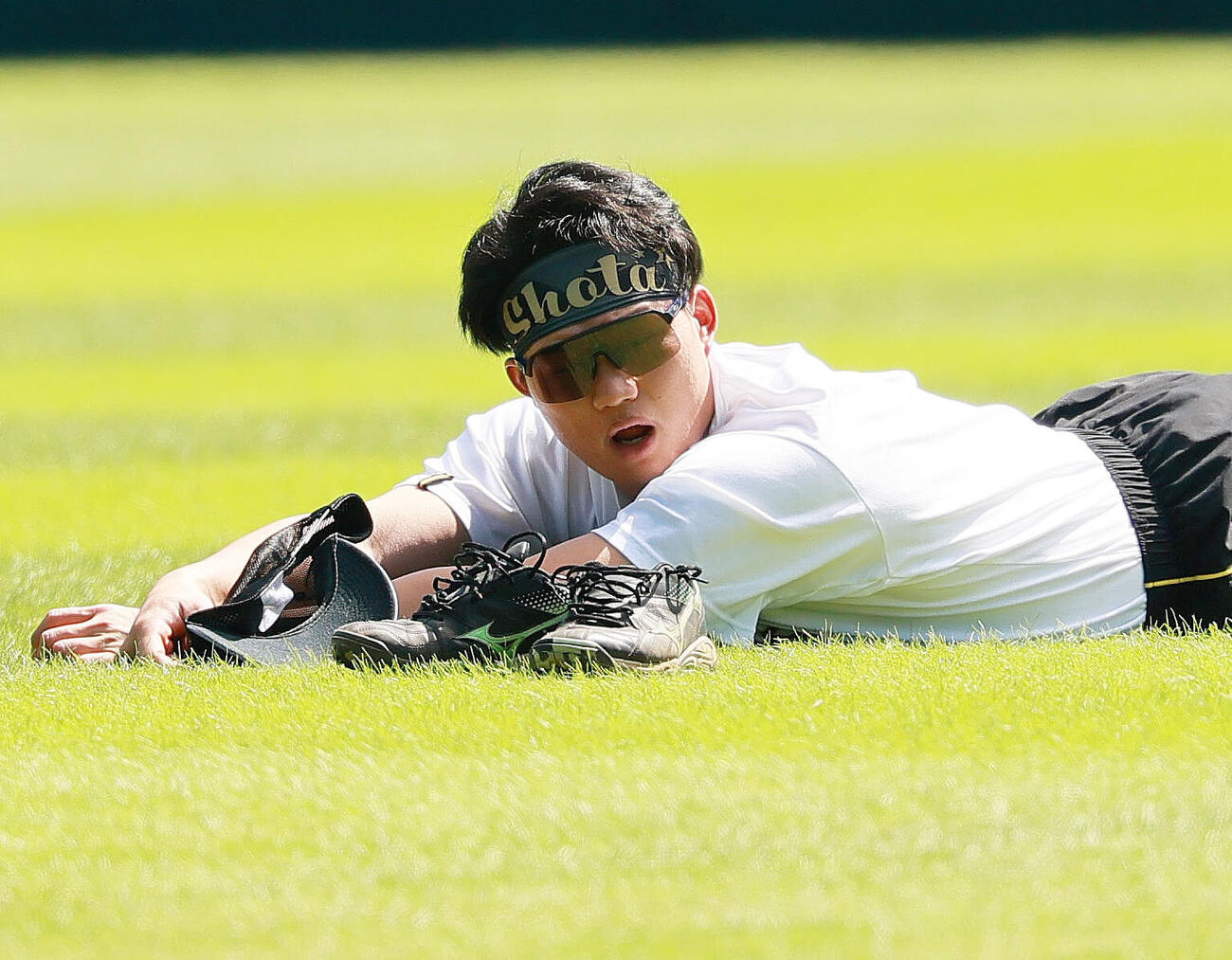 外野で寝そべる森下翔太（撮影・上山淳一）