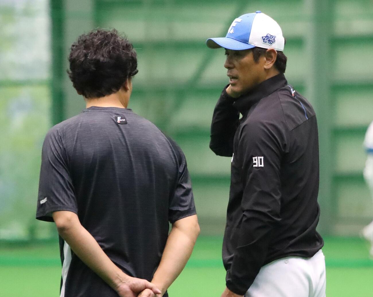 球団スタッフと話す日本ハム稲葉2軍監督（右）