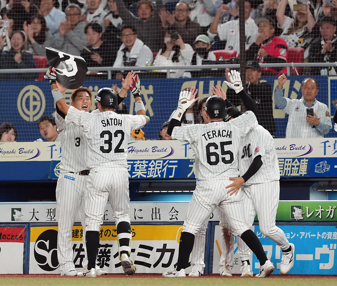 ロッテ対ソフトバンク　8回裏ロッテ2死、右越えに2点本塁打を放った佐藤都志也を迎える角中勝也（左）（撮影・たえ見朱実）