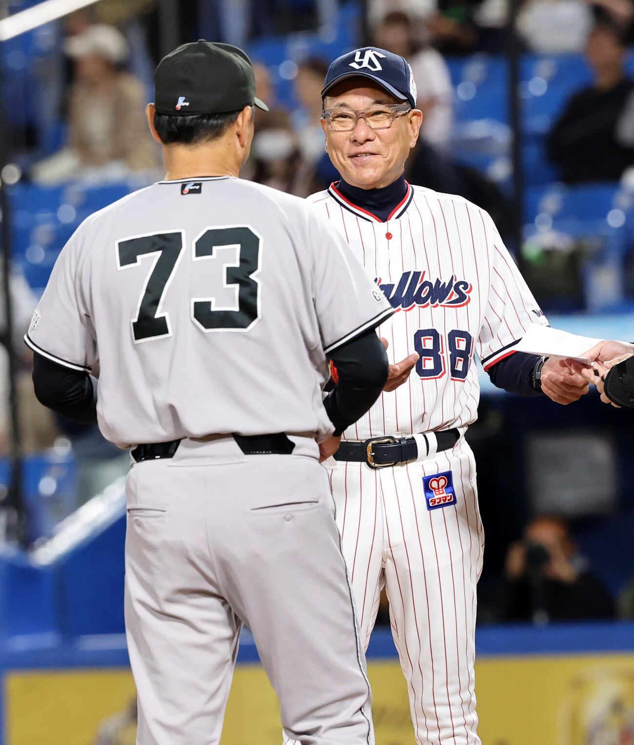 ヤクルト対巨人　メンバー最終確認で、巨人橋上秀樹監督代行（手前）に笑顔であいさつするヤクルト池山隆寛監督（撮影・浅見桂子）