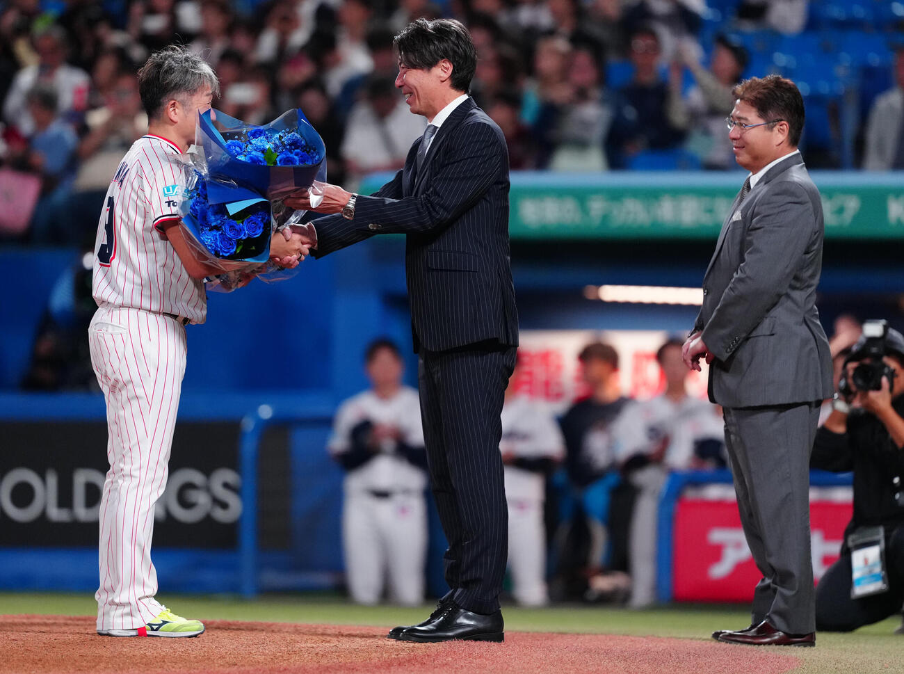 ヤクルト対中日　試合前、引退するヤクルト石川雅規（左）は高津臣吾氏から花束を受け取る。右は真中満氏（撮影・鈴木みどり）