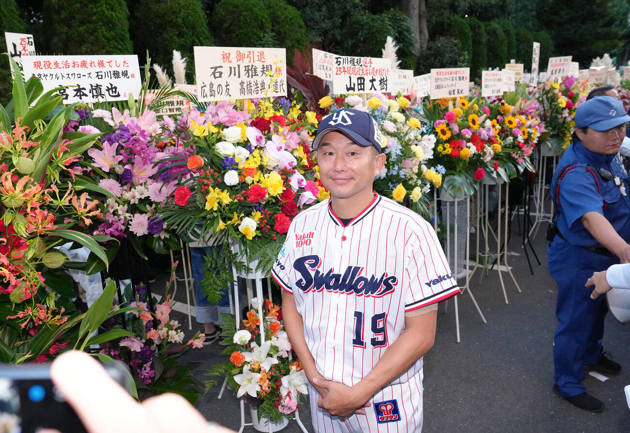 ヤクルト対中日　試合前、贈られた花を背に笑顔を見せるヤクルト石川雅規（撮影・足立雅史）