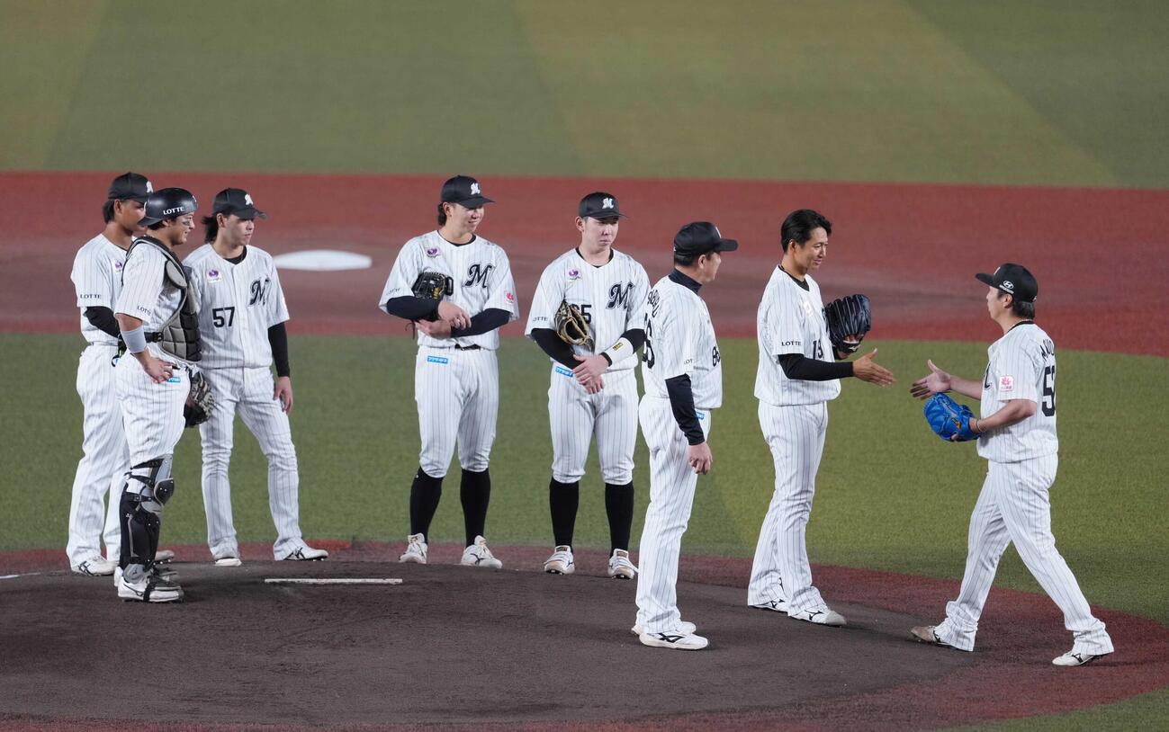 ロッテ対ソフトバンク　1回表ソフトバンク1死、引退登板を終えた唐川侑己は2番手でマウンドへ向かった益田直也（右）と握手する（撮影・小沢裕）
