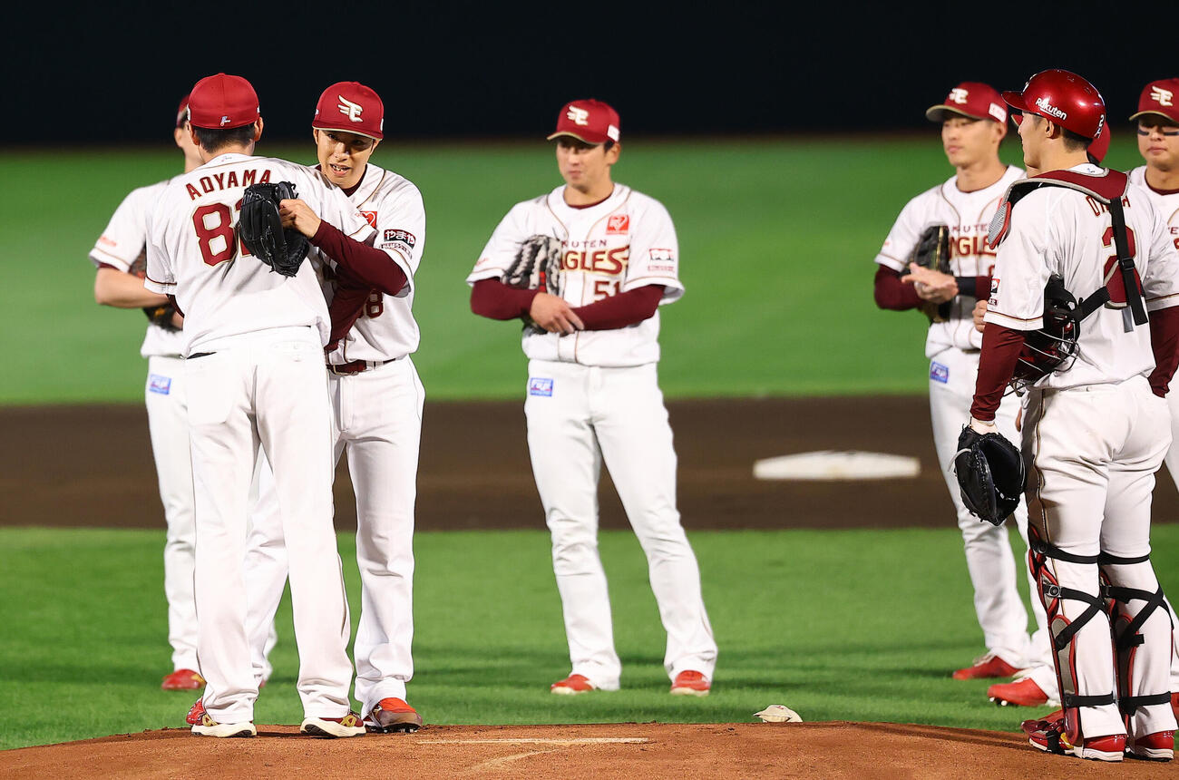 楽天対オリックス　1回表オリックス1死、引退登板を終え青山浩二コーチと抱きあう辛島航（撮影・野上伸悟）