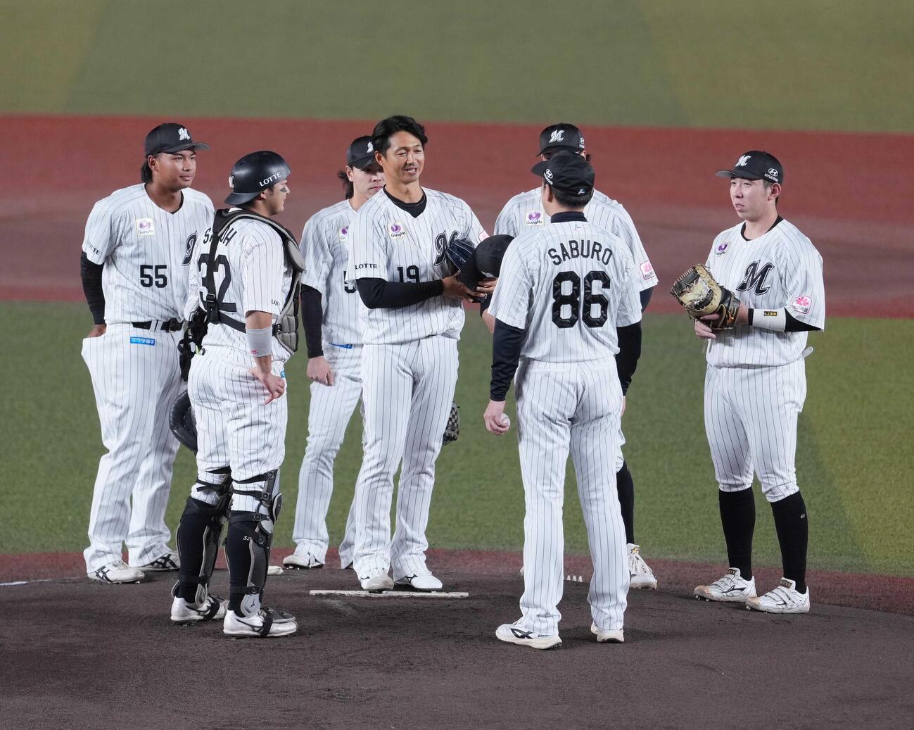 ロッテ対ソフトバンク　1回表ソフトバンク1死、引退試合で登板を終えたロッテ唐川侑己（中央）はサブロー監督らナインからねぎらわれる（撮影・小沢裕）