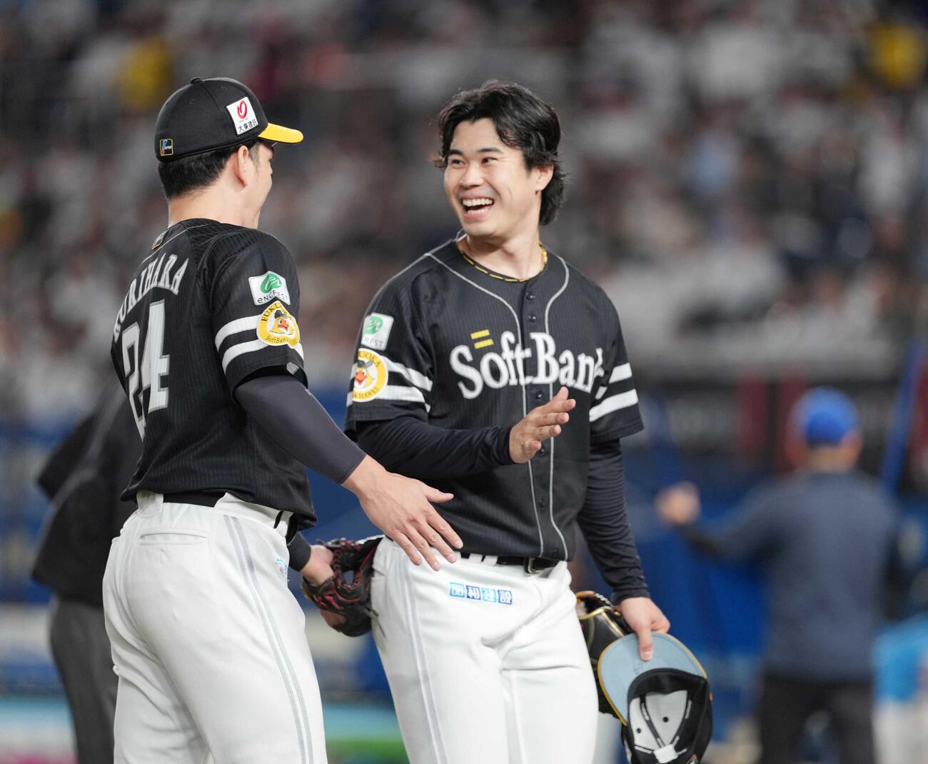 ロッテ対ソフトバンク　5回の投球を終えたソフトバンク先発の松本晴（右）は栗原陵矢と談笑しながらベンチへ引き揚げる（撮影・小沢裕）