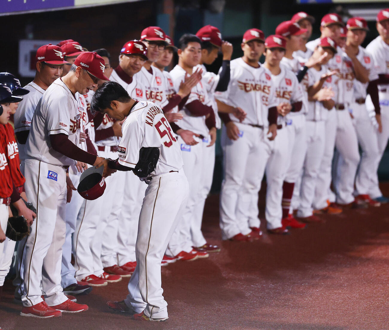 楽天対オリックス　1回表オリックス1死、引退登板を終え吉井理人監督（手前左）らに迎えられる楽天辛島航（撮影・野上伸悟）
