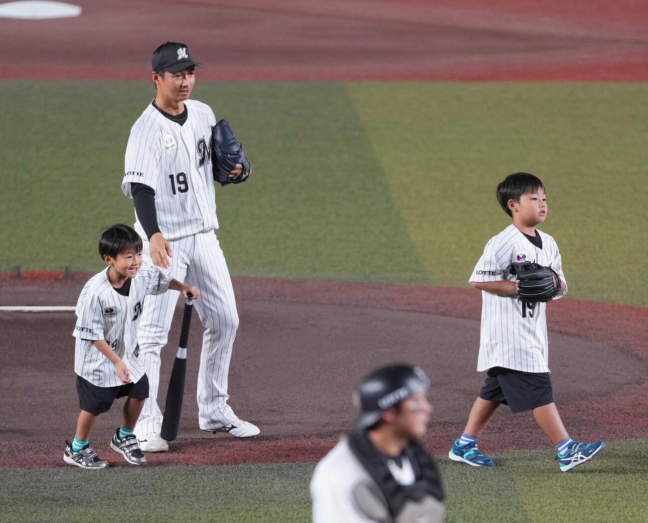 ロッテ対ソフトバンク　引退登板に臨むロッテ先発の唐川侑己は始球式を行った次男ハルキくん（左）、長男アユキくんをマウンドで迎える（撮影・小沢裕）
