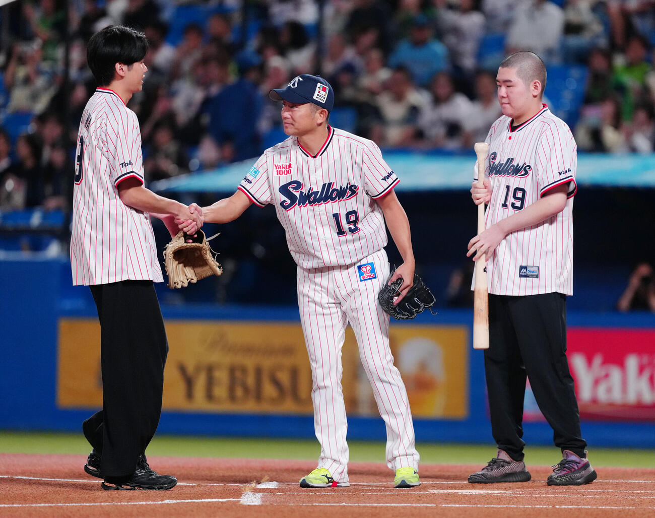 ヤクルト対中日　セレモニアルピッチを終え長男大耀さん（左）と握手を交わすヤクルト石川雅規。右は次男栄寿さん（撮影・鈴木みどり）
