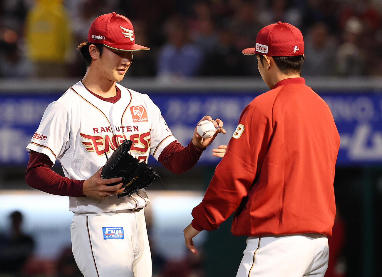 引退する辛島航（右）にウイニングボールを渡す楽天古謝樹（撮影・野上伸悟）